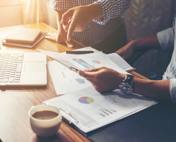 Financial documents in front of laptop
