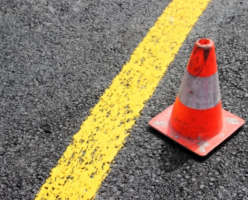 orange construction cone next to yellow line