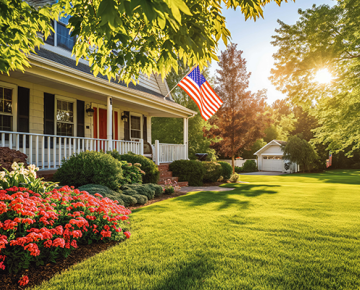 home with green grass and red bushes