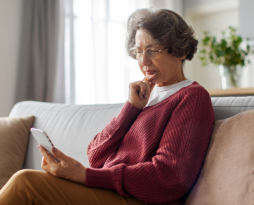 elderly woman on couch looking at phone