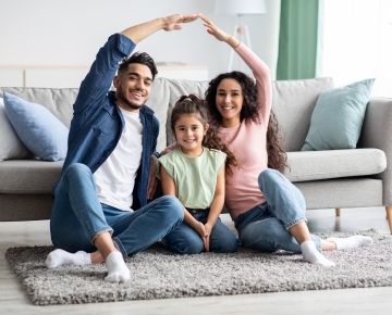 family sitting on floor in front of couch