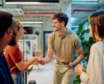 four coworkers shaking hands in the office