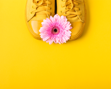 yellow shoes on yellow background with pink flower