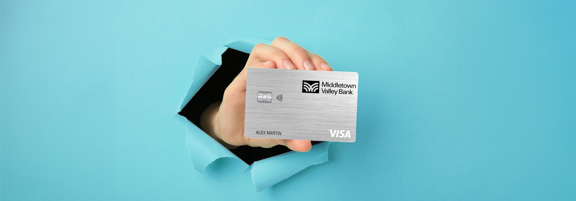 Hand holding credit card through blue paper.  