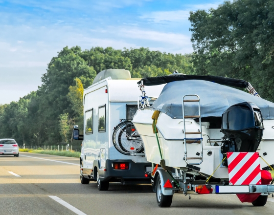 RV pulling a boat on the road. 