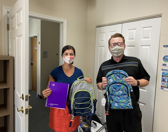 woman and man holding school supplies